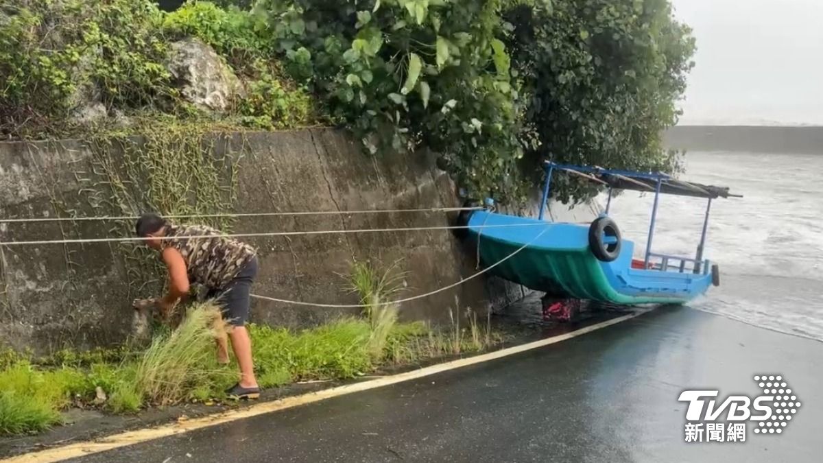 成功鎮石雨傘有竹筏被吹上岸，民眾趕緊先將其固定住。（圖／TVBS）