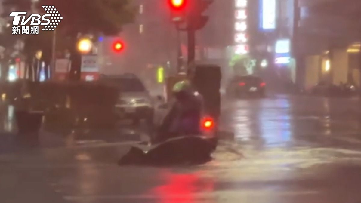 高雄狂風暴雨,騎士支撐不住,機車遭吹倒。(圖/TVBS)