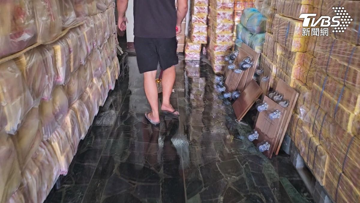 恆春鎮一家金紙店商品全數浸水報廢，店內人員忙著用拖把吸乾積水。（圖／TVBS）