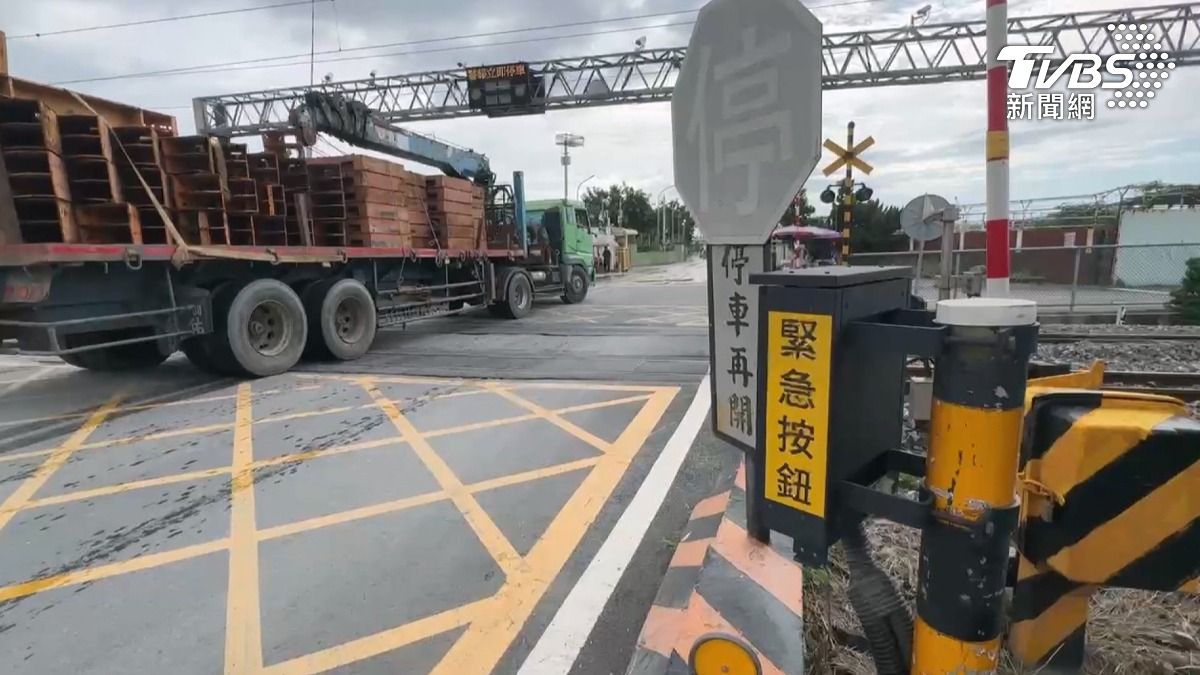 高雄楠梓高楠公路一輛聯結車因車身過重而卡在平交道上,導致台鐵區間車延誤18分鐘。(圖/TVBS)