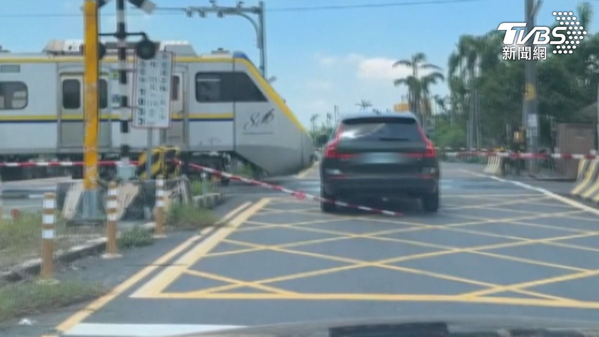 台南柳營一輛黑色休旅車,強行闖越平交道而被遮斷桿卡住,駕駛在緊急情況下倒車撞壞柵欄。(圖/TVBS)
