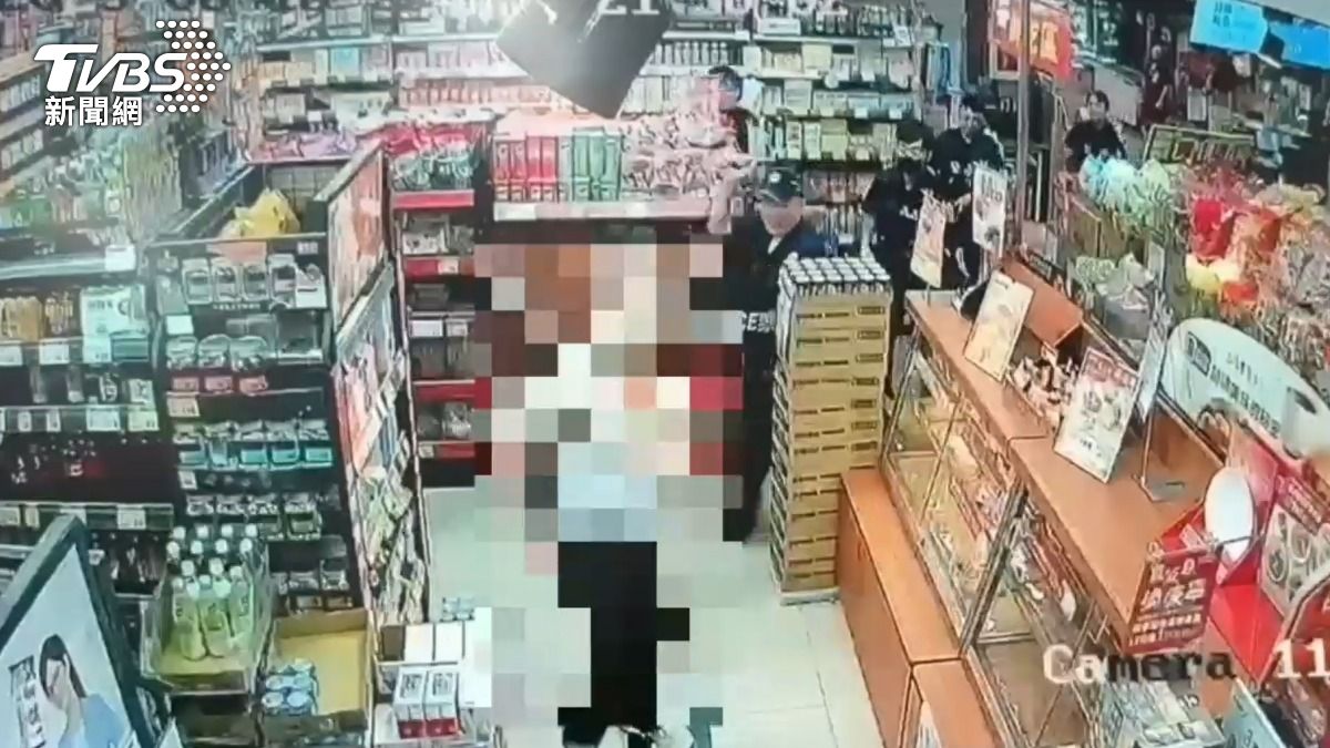 高男在賣場內亮刀,警方持棍棒與其對峙。(圖/TVBS)