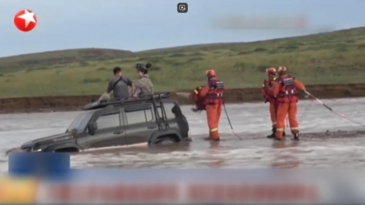 內蒙一夜下了近半年的雨量，越野車被困泥流，兩人爬車頂求援。（圖／上海東方衛視）