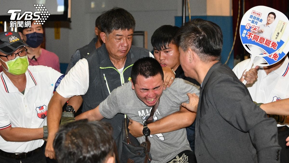 「吃屎哥」向台上灑冥紙被壓制帶離。(圖／胡瑞麒攝)