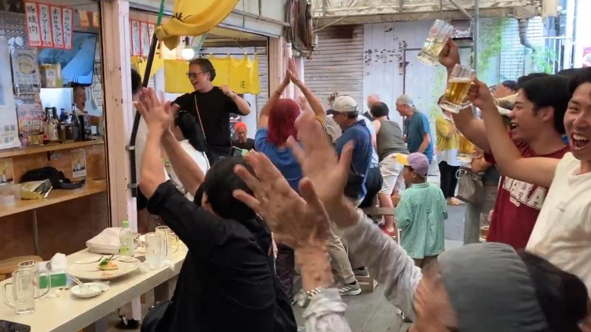 奪冠後,居酒屋的客人舉杯歡呼。(圖/取自X @theokinawatimes)