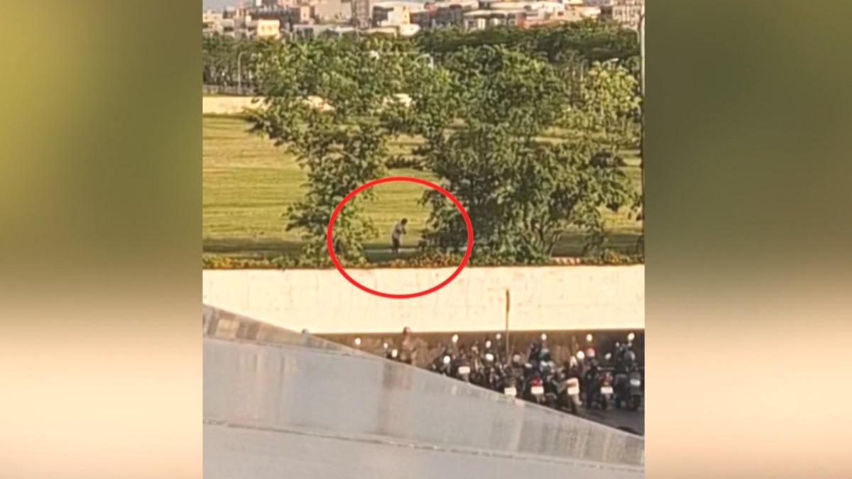 這名男子捷運旁正在打高爾夫球,還在樹蔭下躲太陽,就怕小白球飛出去時,砸傷人怎麼辦(圖/翻攝臉書@高雄爆料公社)