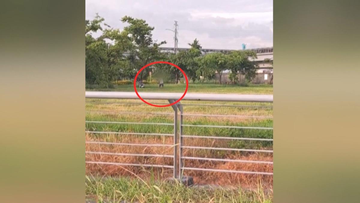 白衣男子揮動球桿,正在練習高爾夫球,他的摩托車就停在一旁,還在樹蔭下躲太陽,就怕小白球砸傷人、影響捷運(圖/翻攝臉書@高雄爆料公社)