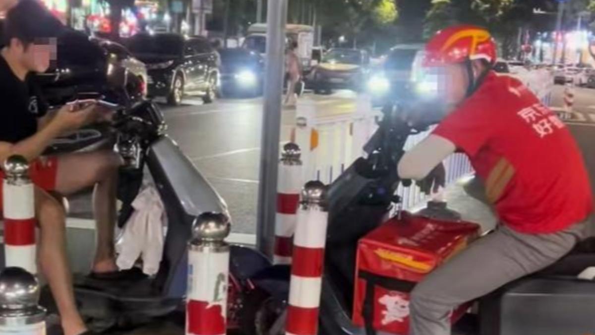 有兩名騎士停著車面對面,誰也不讓誰。 (圖/翻攝自網易@大風新聞)