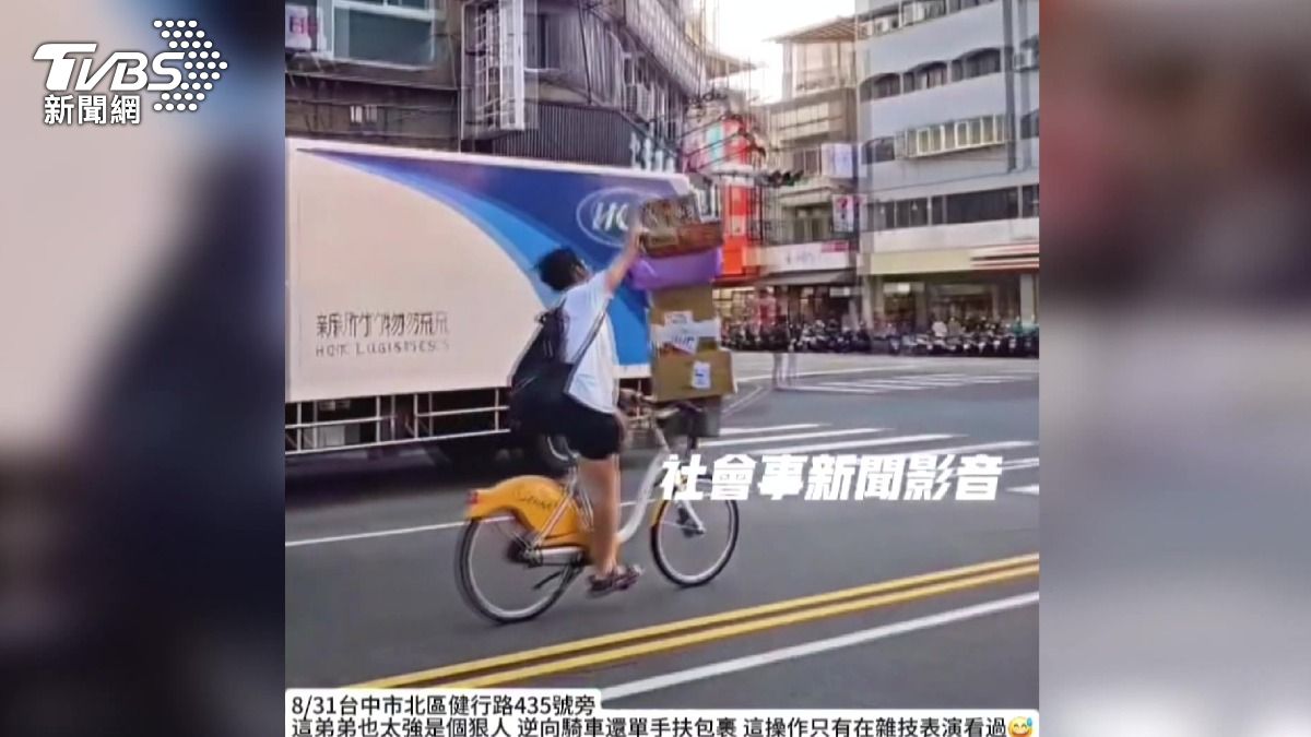 男大生Ubike載6包裹,單手騎車逆向闖紅燈!。(圖/翻攝社會事新聞影音)