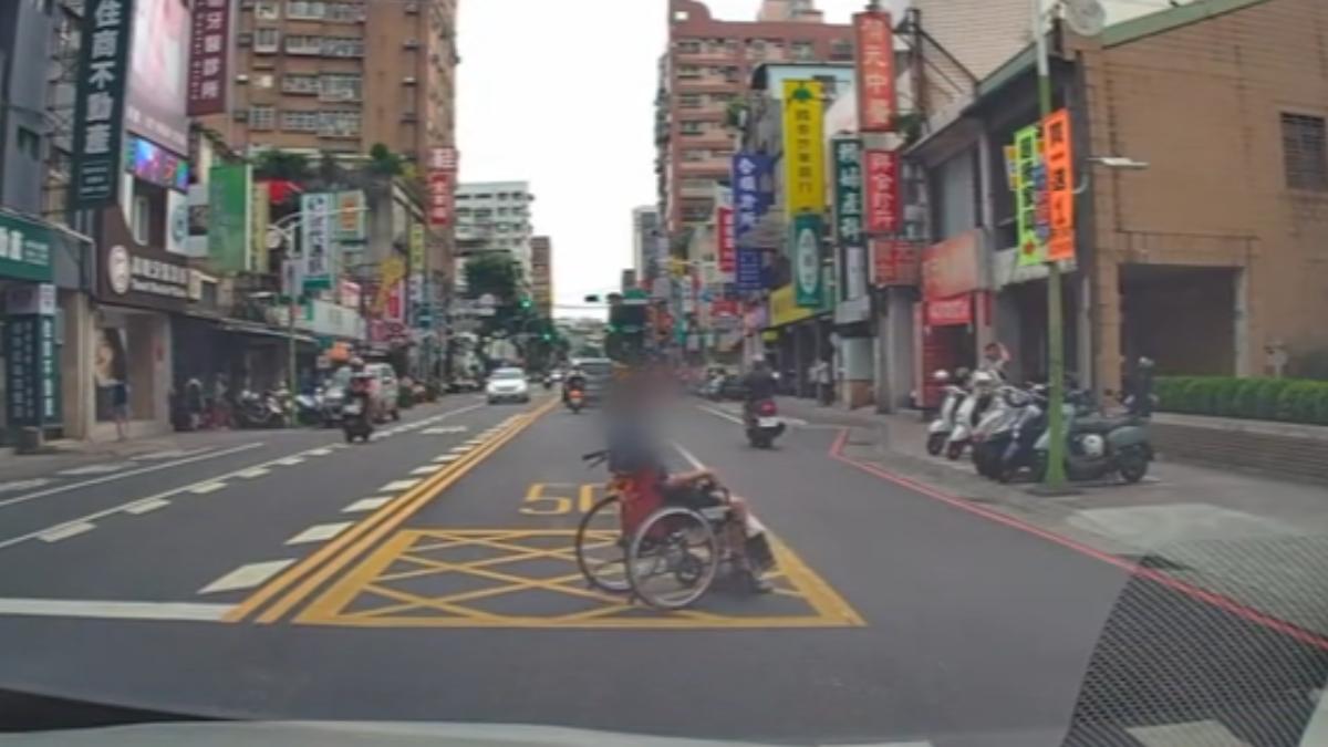 阿公坐輪椅倒退嚕穿越馬路。（圖／授權 kimy_go）
