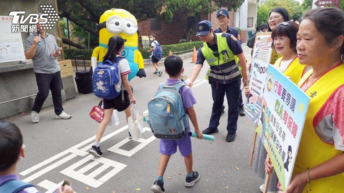 清水分局警方與元氣十足的小小兵玩偶歡欣鼓舞地迎接小朋友上學去。（圖／TVBS）