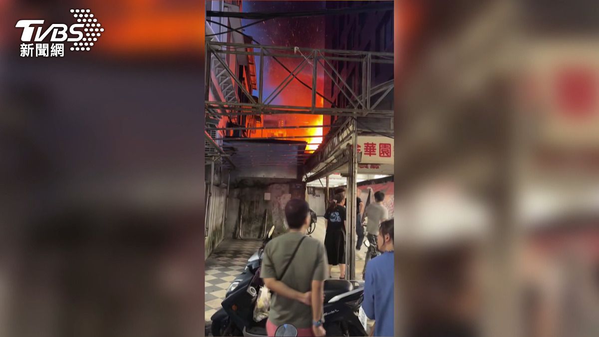 附近民眾發現火勢後立即疏散到安全地帶，站在外圍觀察巷內民宅上方不斷冒出的火光。(圖／消防隊提供)