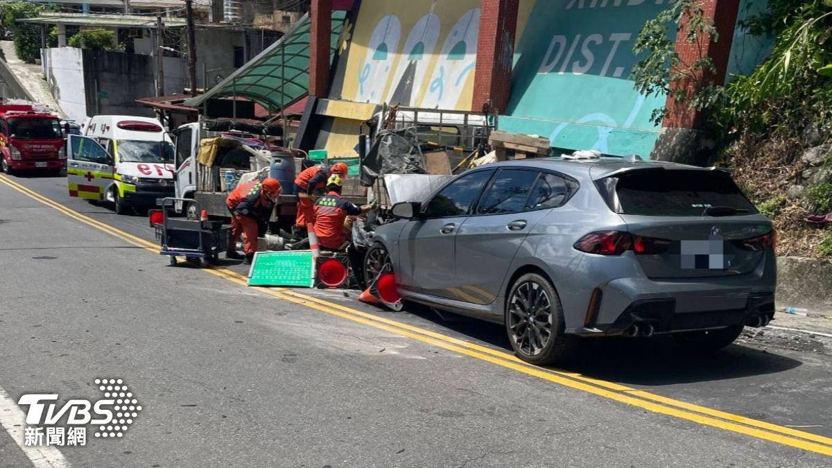 BMW疑似因過彎時下坡速度太快，猛撞旁邊一輛停放的大貨車。（圖／TVBS）