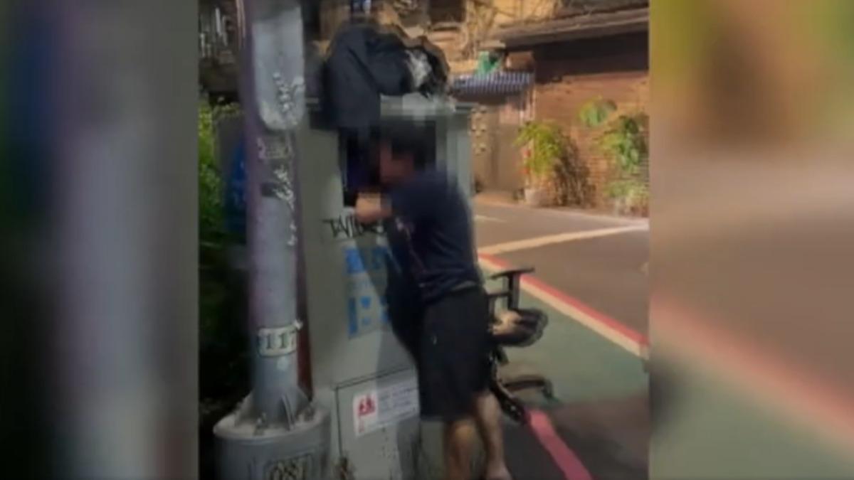 男子把手伸進舊衣回收箱裡,將衣物打包帶走,疑似想當二手衣變賣。(圖/畫面由民眾提供)