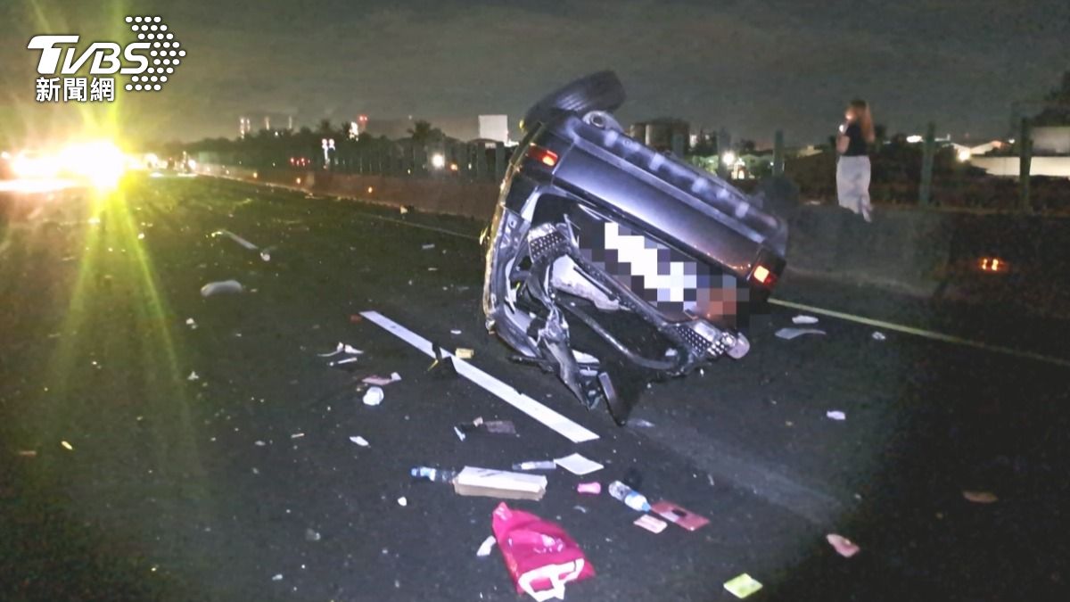 在國道一號台南仁德路段,一輛黑色轎車完全失控翻覆,車輛零件隨之噴飛散落一地。(圖/台南道路救援 張家班)