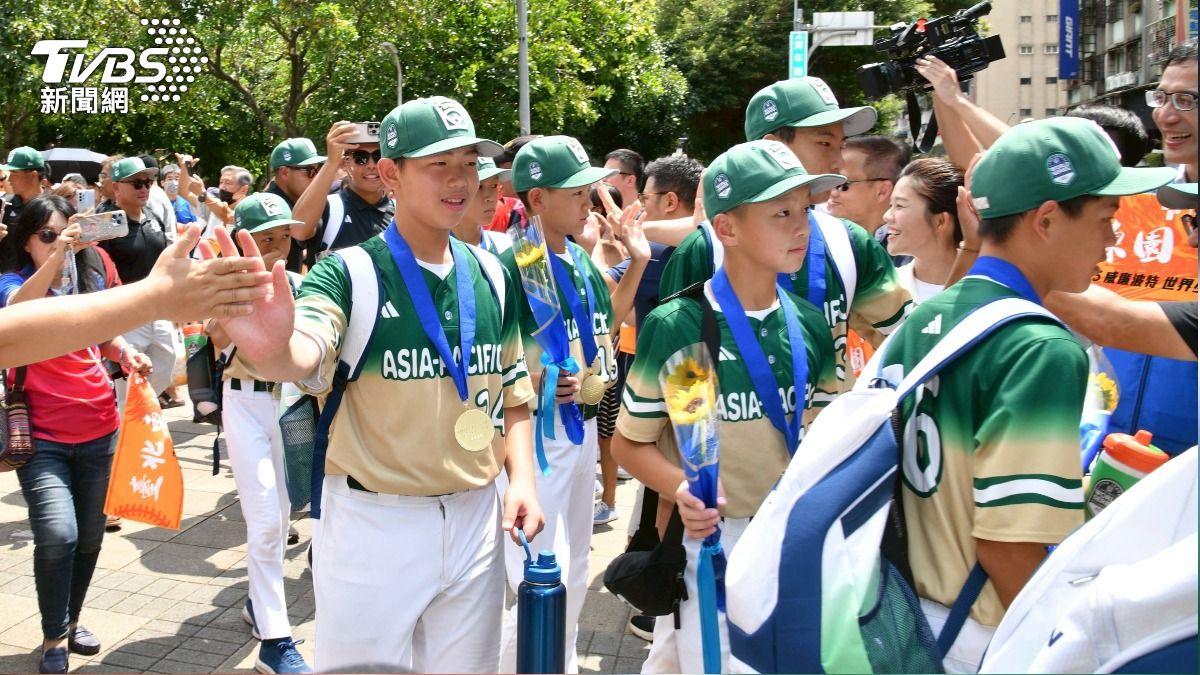 世界冠軍的消息令全台振奮，東園國小少棒隊沿路和民眾擊掌。(圖／胡瑞麒攝)