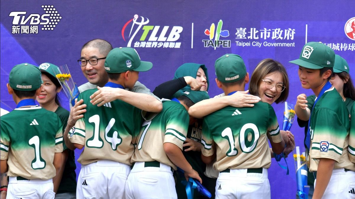 東園國小少棒隊出發遊街前，由家長擁抱小球員並溫馨獻花。(圖／胡瑞麒攝)
