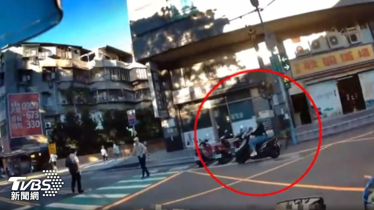 女騎士在警方面前闖紅燈,但她表示不是故意,視線被公車擋住。(圖/TVBS)