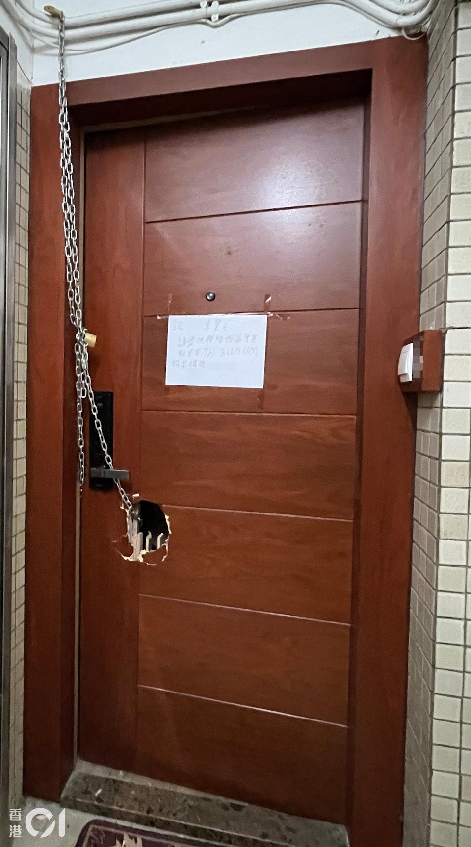 員警在大門鎖上鐵鍊,並貼上告示呼籲住戶聯絡警方。(圖/香港01)