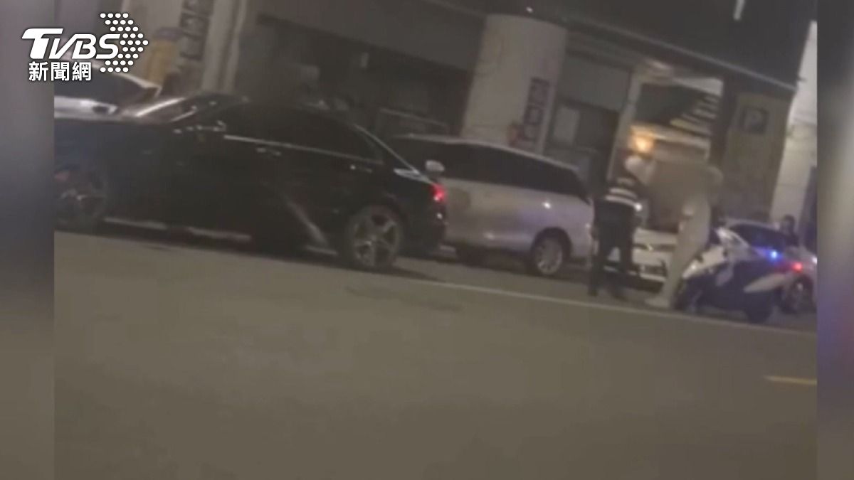 酒吧外,醉酒的白衣男子,不斷地大聲咆嘯,警方到場勸阻。(圖/TVBS)