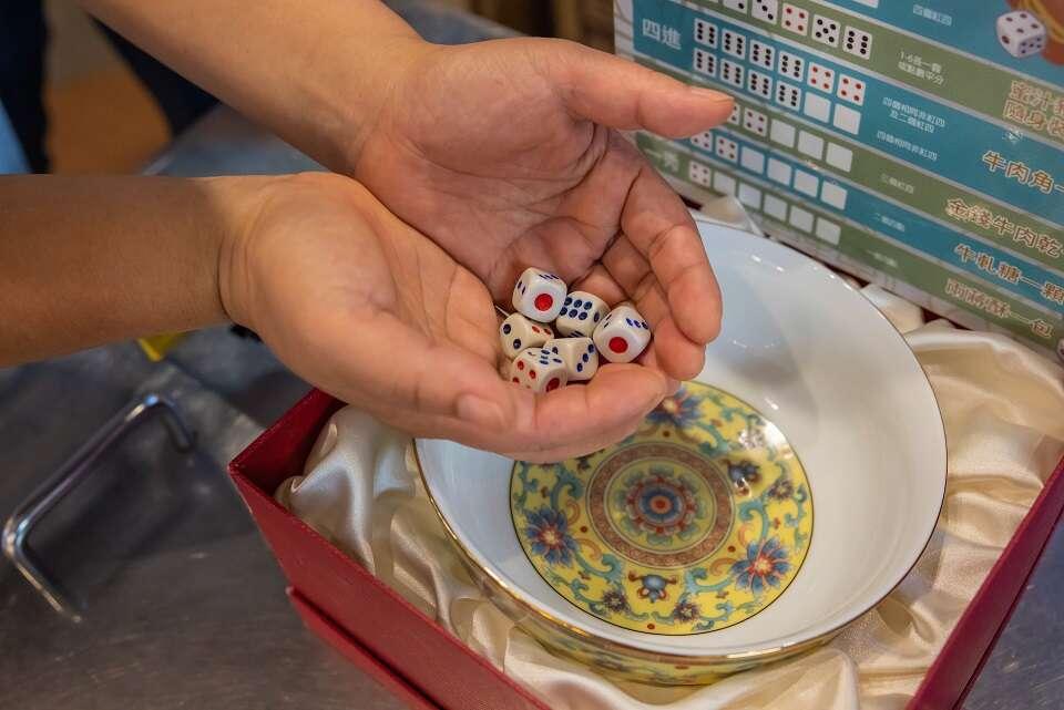 博餅是用6顆骰子投擲碗裡比花色大小。(圖/金門縣政府)