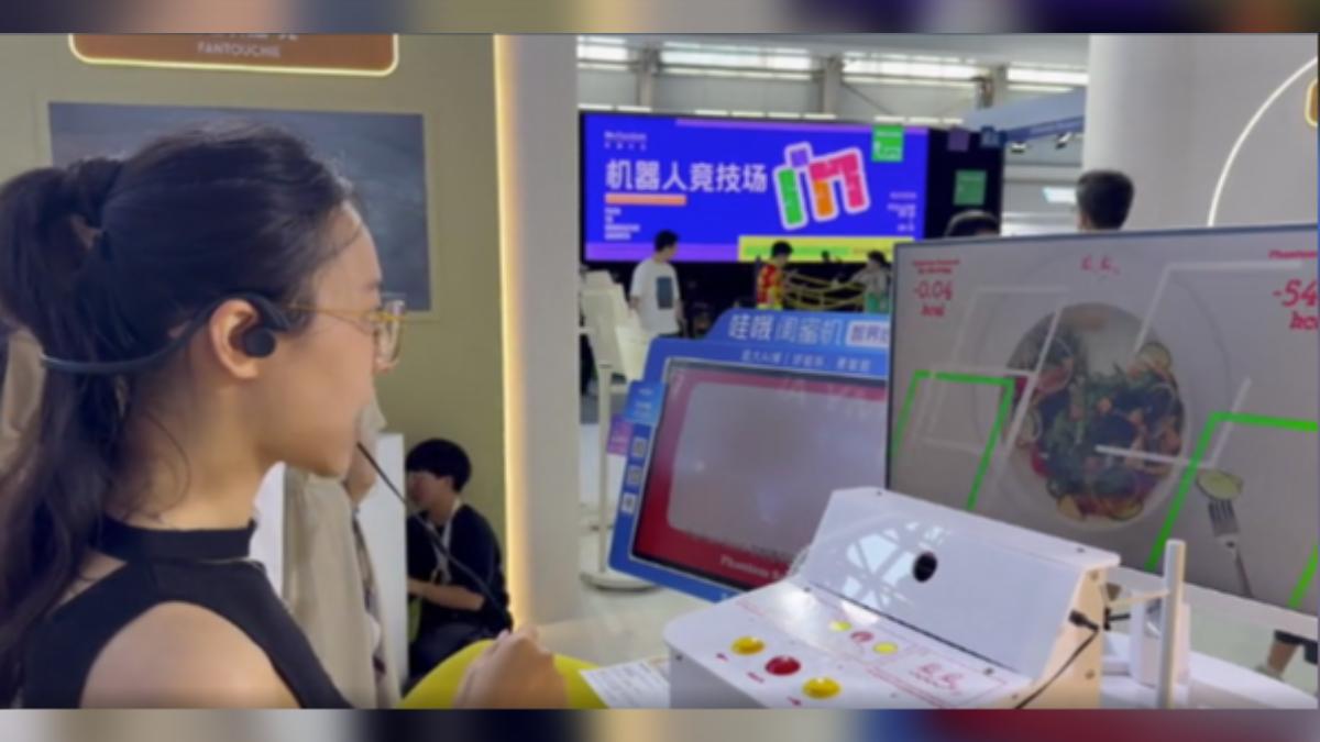 上海科技展出現一款名為「幻覺零食」的裝置,業者宣稱,使用者透過聽覺、視覺和嗅覺,可以假裝吃進高熱量零食,卻不會攝取熱量。(圖/CNS)