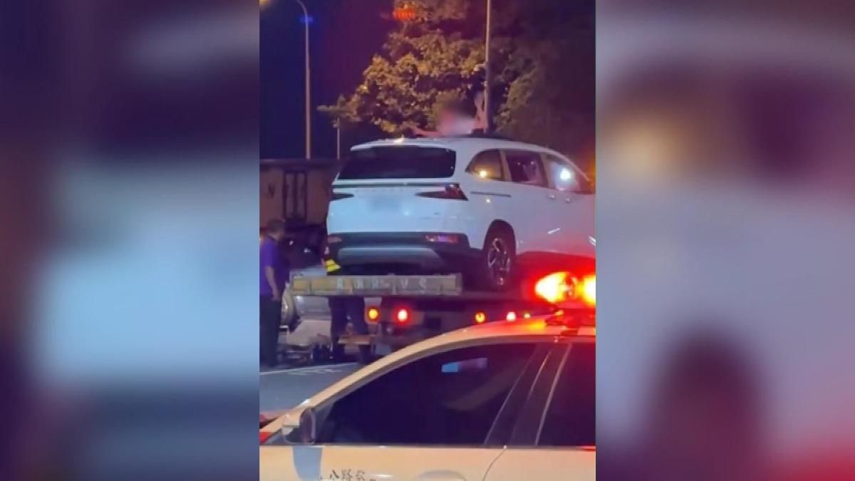 女子違停西螺服務區,情緒失控爬上拖吊車與警對峙。(圖/民眾提供)