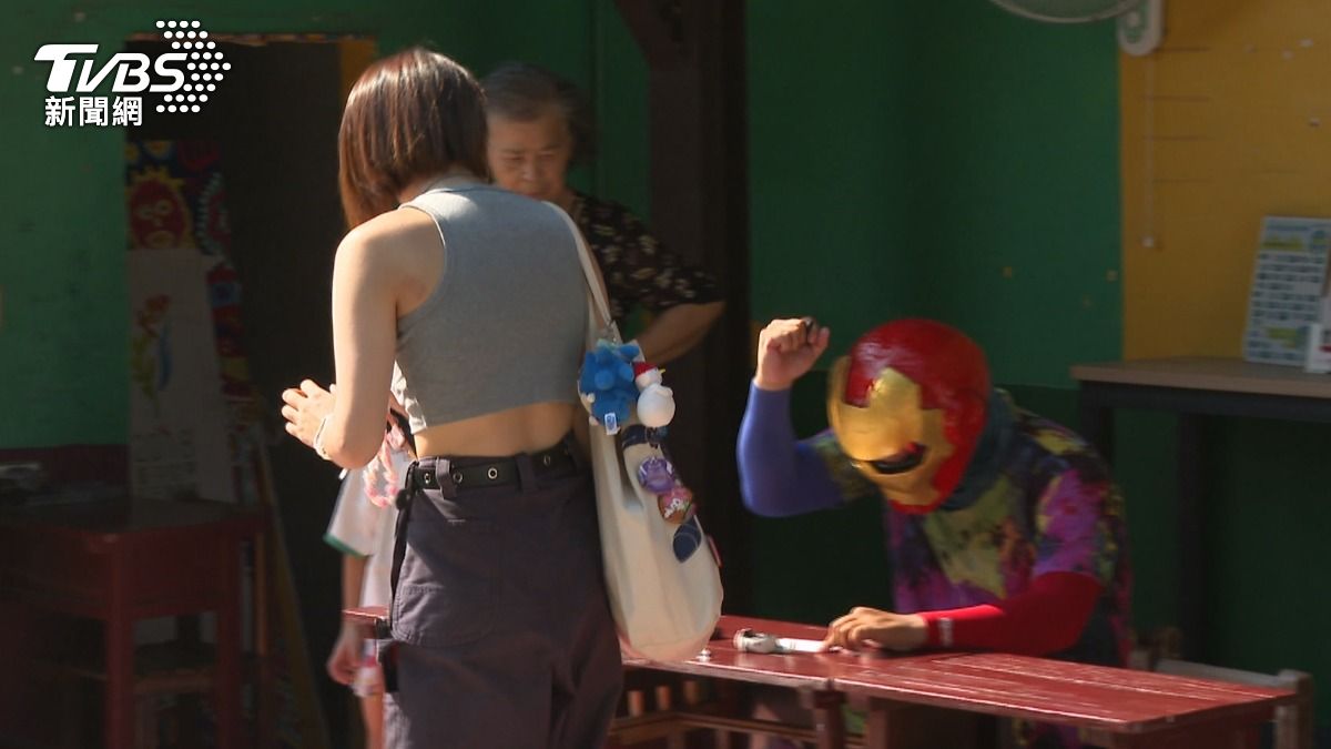 「彩虹戰士」送手寫明信片,與遊客互動帶來驚喜。(圖/TVBS)