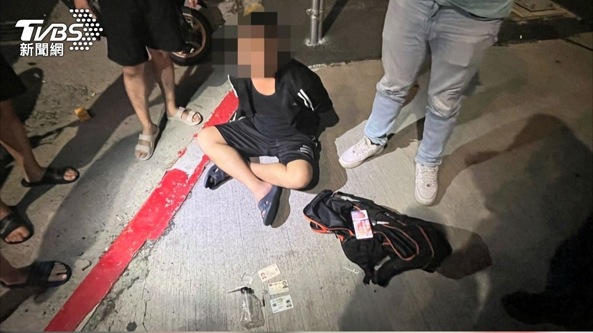 林姓男子被逮捕時盤腿坐在地上,雙手被銬在背後。(圖/TVBS)