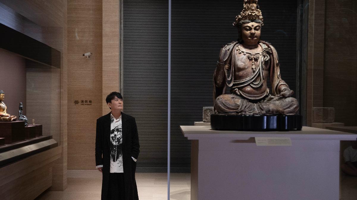 導演捕捉張信哲與字畫、佛像對話的沉靜感。(圖/潮水音樂提供)