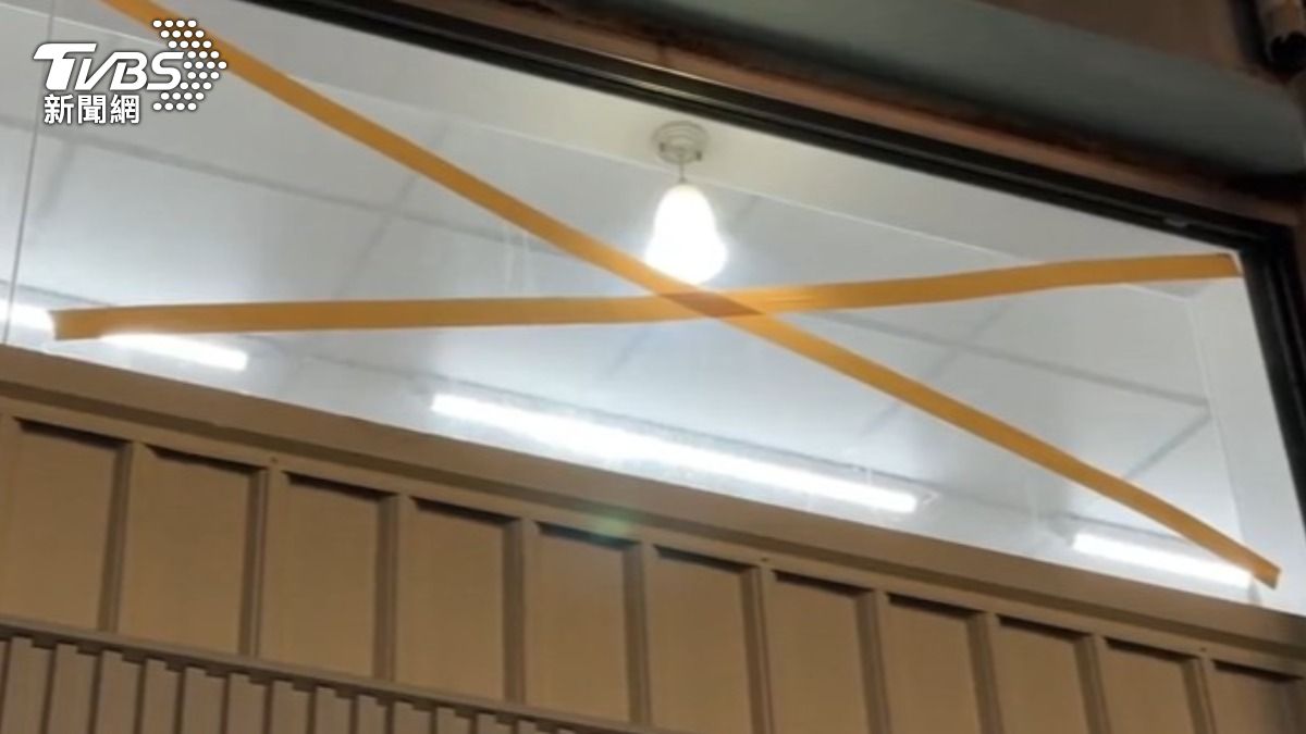 市區民眾防颱準備,在玻璃貼上膠帶,能先拆掉的招牌也先預拆。(圖/TVBS)