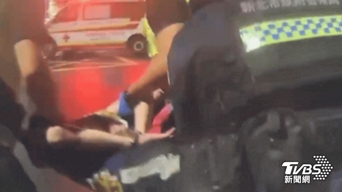 拉扯攻擊救護員！男遭上銬，「扛」進救護車。（圖／TVBS）