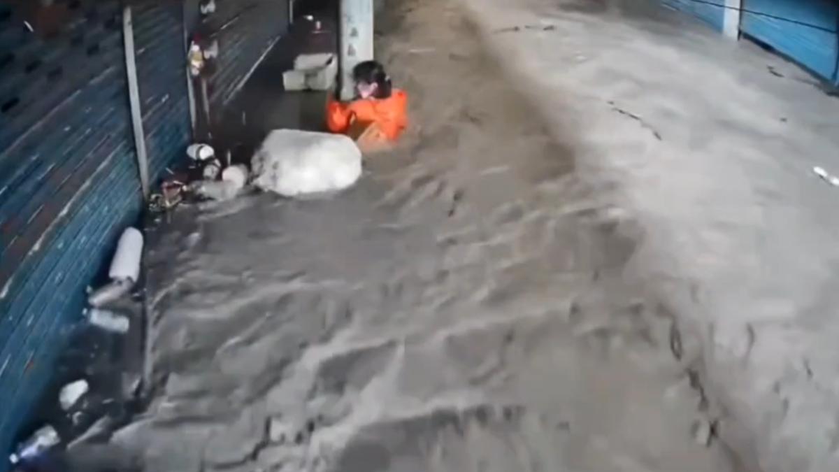 大量泥水灌進光復市場，一名婦人緊抱梁柱避免被沖走。（圖／民眾提供）