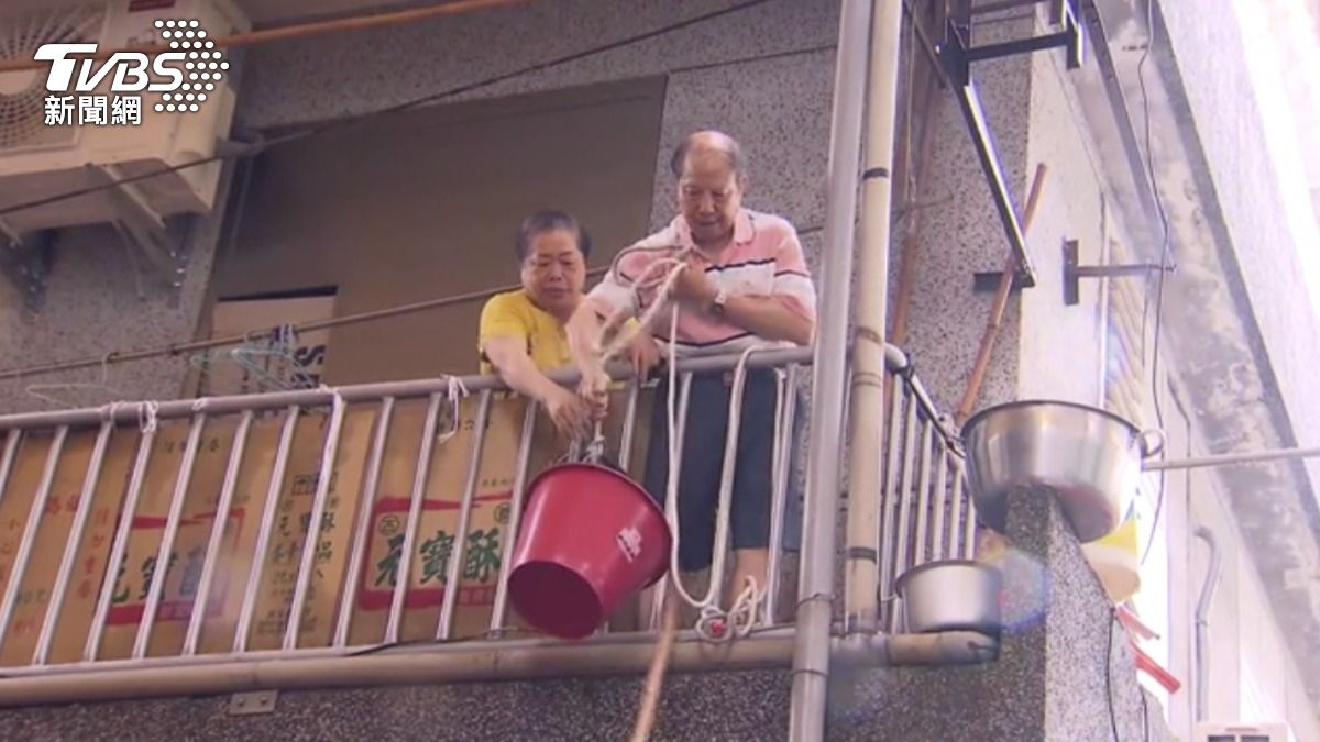 居民受困,只能用水桶運送瓶裝水。(圖/TVBS)