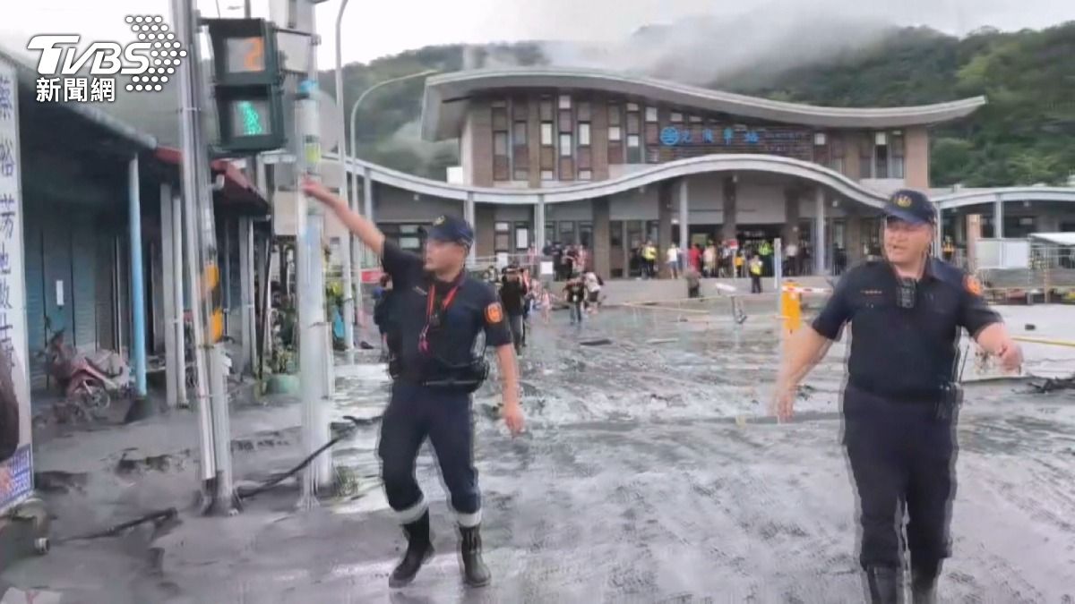 車站前突然響起刺耳的警笛聲,員警揮手指揮疏散人群。(圖/TVBS)
