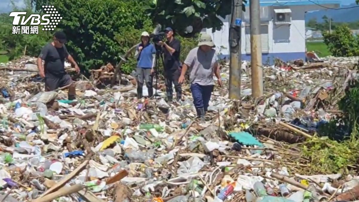 大量垃圾堆積在馬路上,災民只能踏著垃圾海前行。(圖/TVBS)
