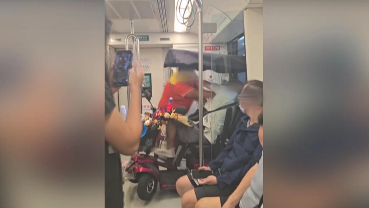 一名騎乘電動代步車的身障男子,因下車動線被阻擋而提醒另一名橘衣男子,卻引發對方不滿。(圖/爆料公社)