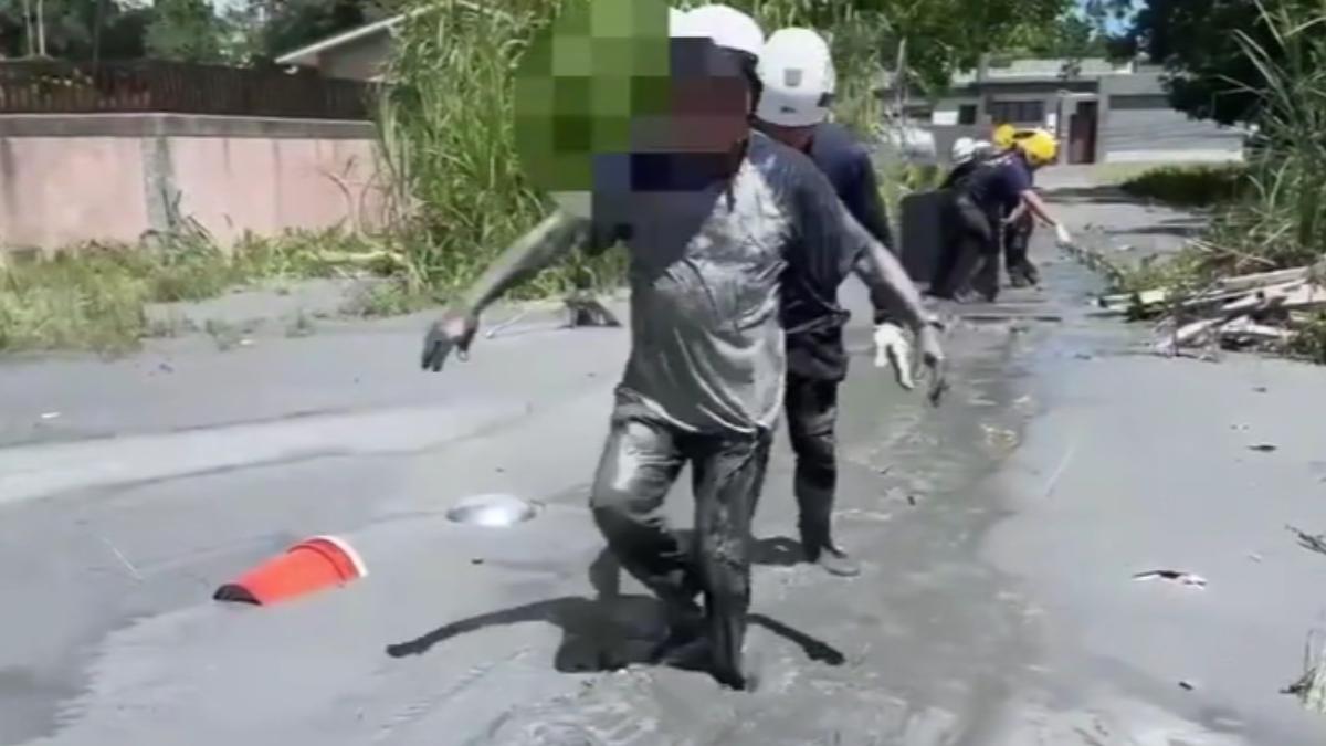 男子為了拍受困於泥沼的車輛，自己也深陷泥沼中，險遭滅頂！（圖／TVBS）