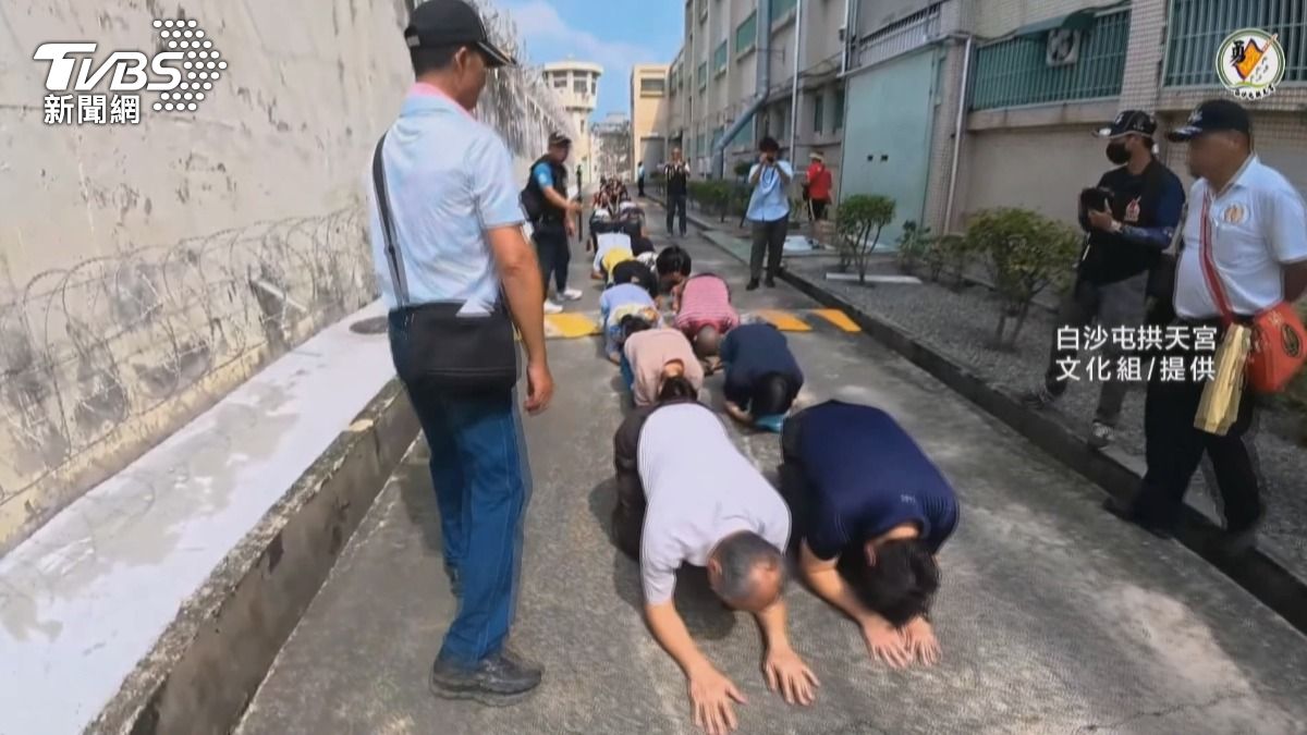 粉紅超跑鑾轎入獄，收容人跪拜祈福。(圖／白沙屯拱天宮提供)