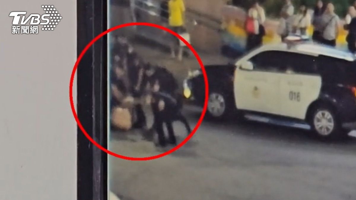 駕駛爬上車頂嗆警,當街遭管束。(圖/TVBS)