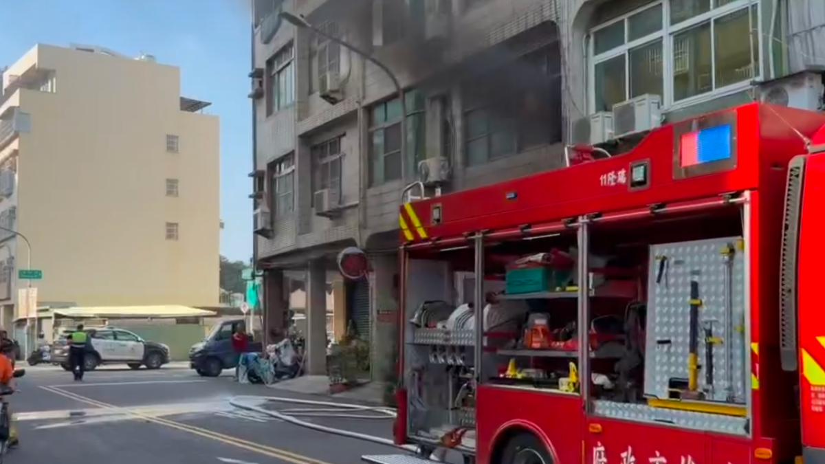 二樓窗戶冒出黑煙,警方至現場指揮周圍交通。(圖/民眾提供)