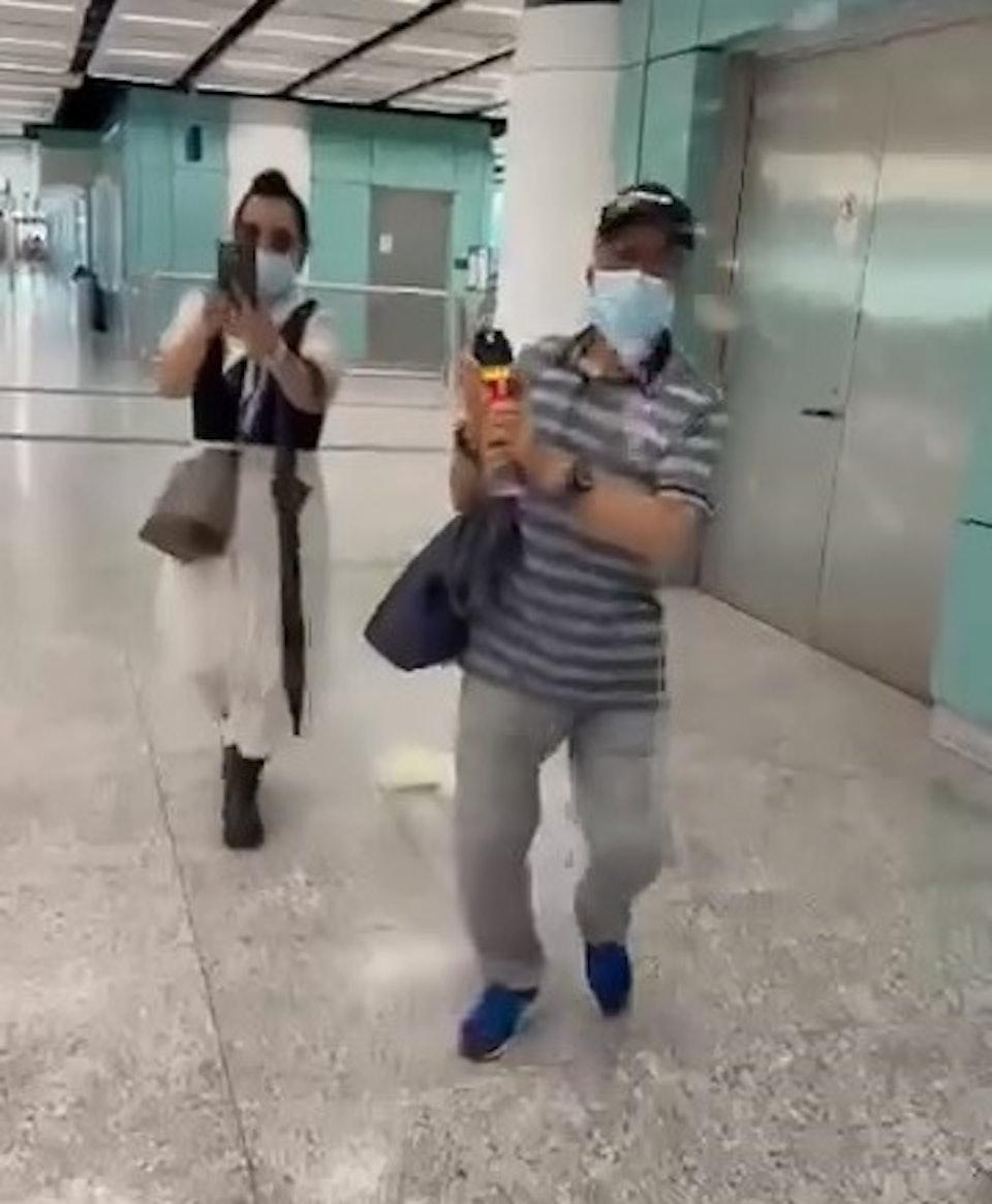 何伯拿出一樽殺蟲水向事主噴射,何太在旁拍攝情況。(圖/網上片段截圖)