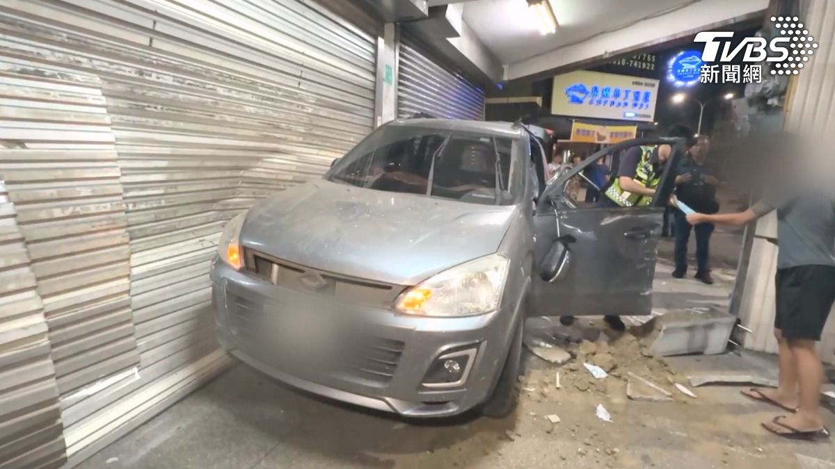 轎車半夜突然衝撞店家鐵門，撞擊力道住戶直呼像是地震一樣，鐵門、鋁門全被撞壞，消防人員把門鋸開才能進出（圖／TVBS）