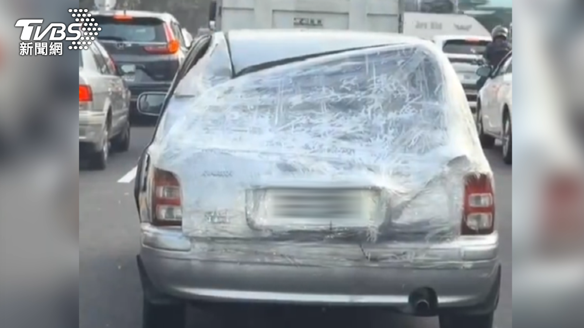 這輛小轎車車門鈑金凹陷、車頂損毀、後擋風玻璃破損，卻僅以膠帶簡易包覆繼續行駛。（圖／翻攝社會事影音）