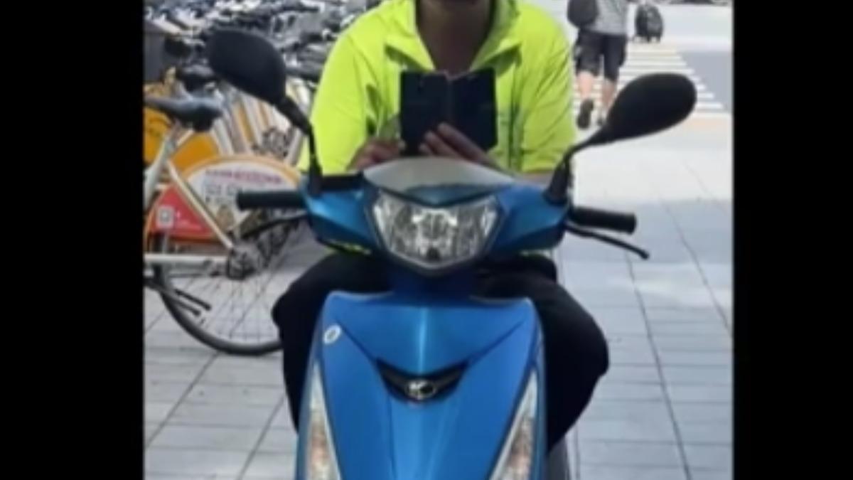 坐在機車上男子,遭控出沒在海山捷運站周圍,拿手機偷拍。(圖/畫面取自臉書:我是土城人)