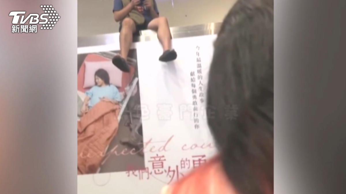 更誇張的是，男子一度將身體朝向手扶梯，兩隻腳完全懸在半空中，下方正是人來人往的手扶梯。（圖／黑色豪門企業）