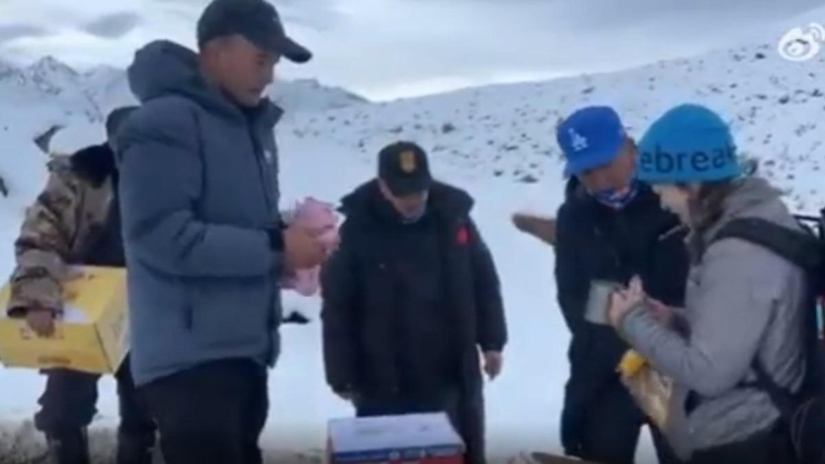 珠穆朗瑪峰遭遇罕見暴雪與強降雨,導致上千名陸登山客受困村民為他們送上食物。(圖/翻攝微博 九派新聞)