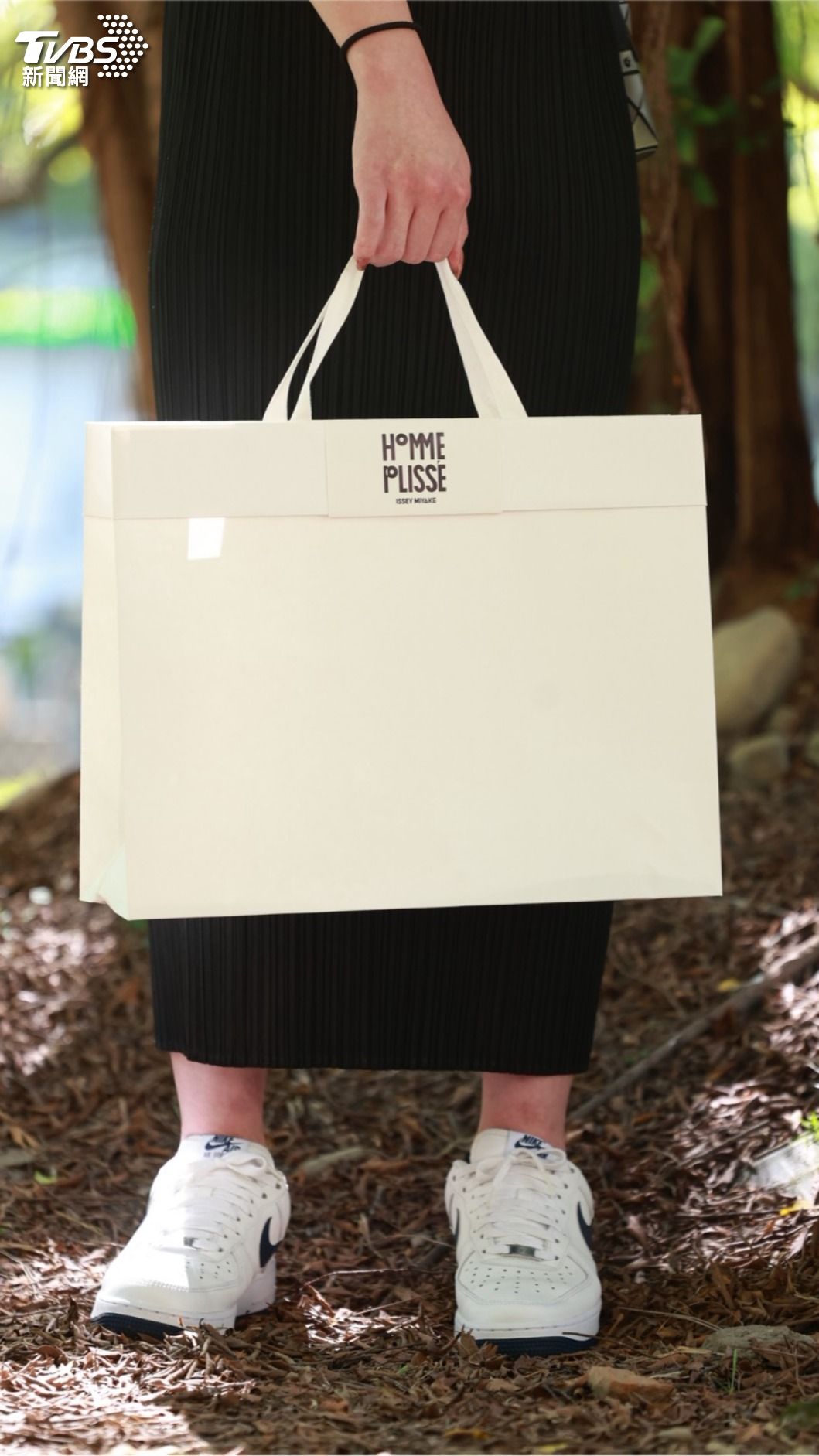Fumi 阿姨今日露面,依舊帶著「HOMME PLISSÉ ISSEY MIYAKE」的紙袋。(圖/華子琛攝)