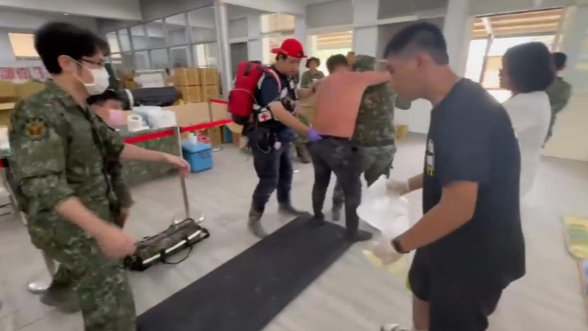 一名志工因熱衰竭高燒到38.5°C被送到救護站,由救護人員進行降溫。(圖/TVBS)
