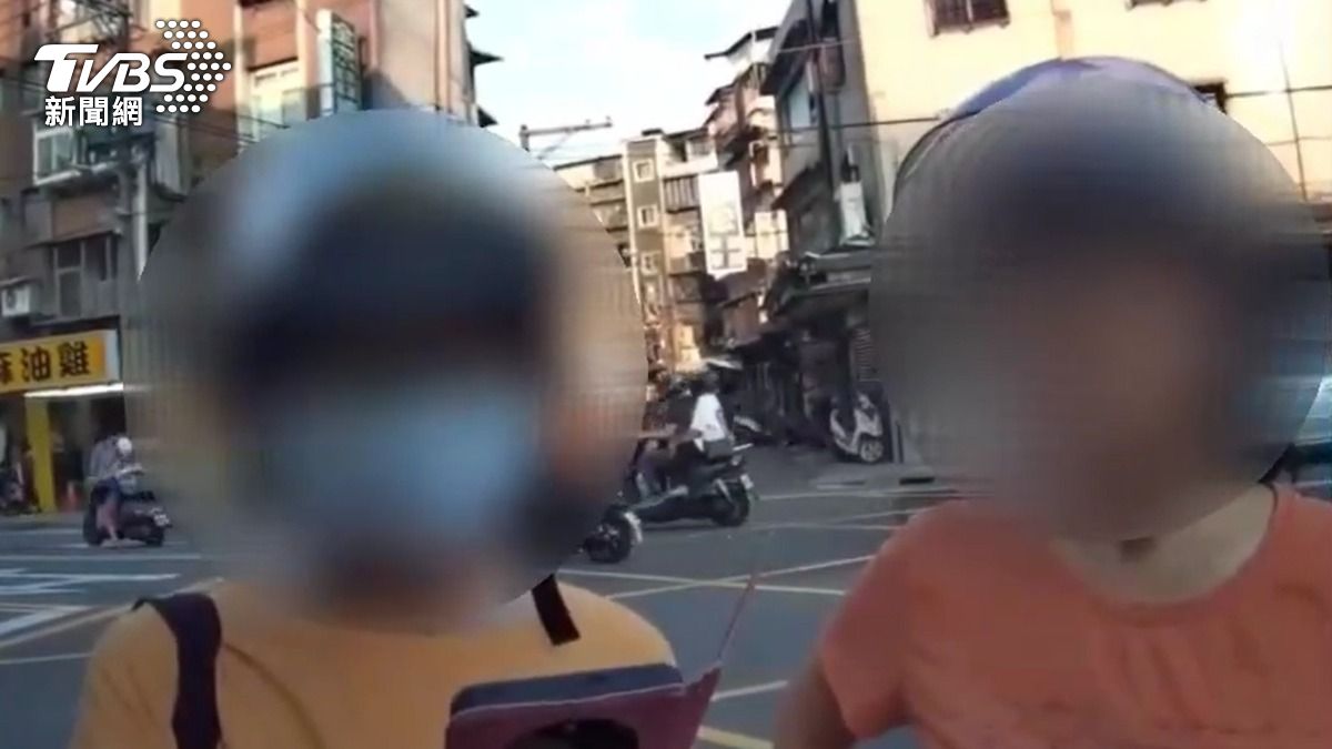 婦人騎機車停紅燈時用手機遭員警攔查開單。（圖／TVBS）
